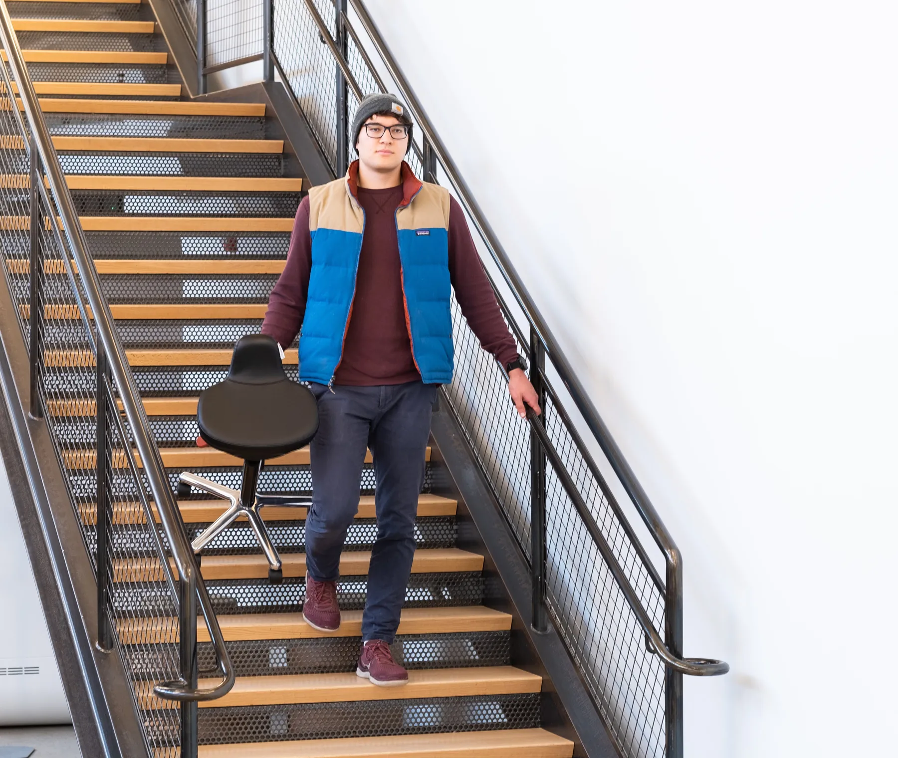 Man carrying the Ariel 2.0 by its handle down a staircase